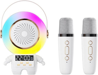 A white robot-shaped karaoke speaker set with a colorful rainbow LED ring, a digital display, and two matching white microphones with gold accents on a plain white background. Astro Speaker