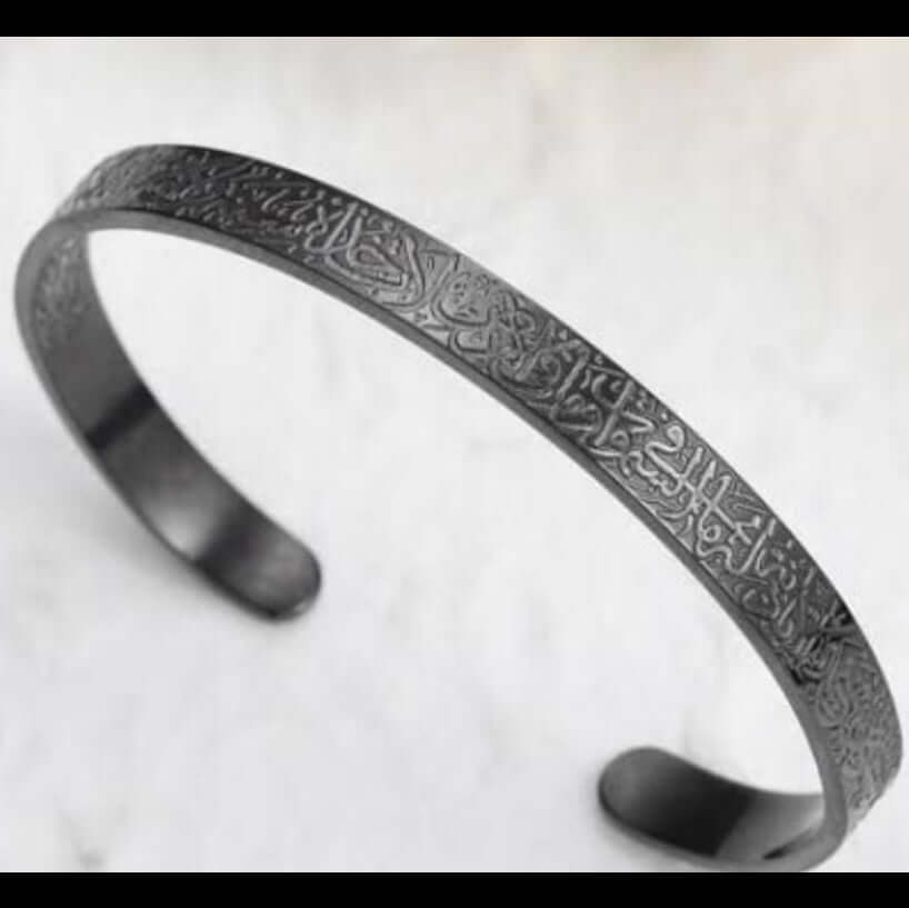 Black metal bracelet with engraved design on a white background. Ayatul Kursi engraved bracelet