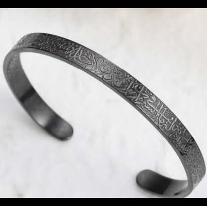 Black metal bracelet with engraved design on a white background. Ayatul Kursi engraved bracelet
