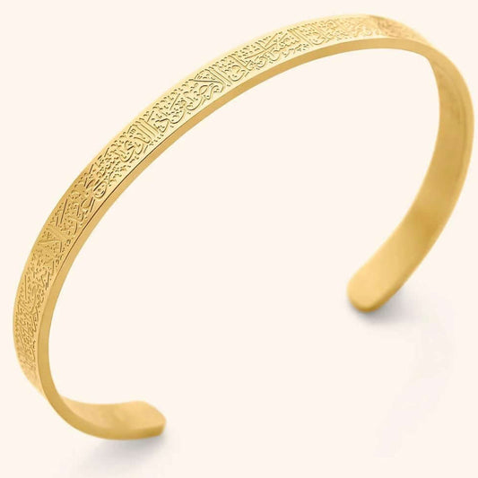 Gold bracelet with intricate patterns on a light beige background. Ayatul Kursi engraved bracelet