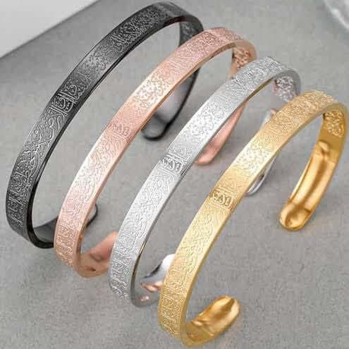 Four bracelets in black, rose gold, silver, and gold on a gray surface. Ayatul Kursi engraved bracelet