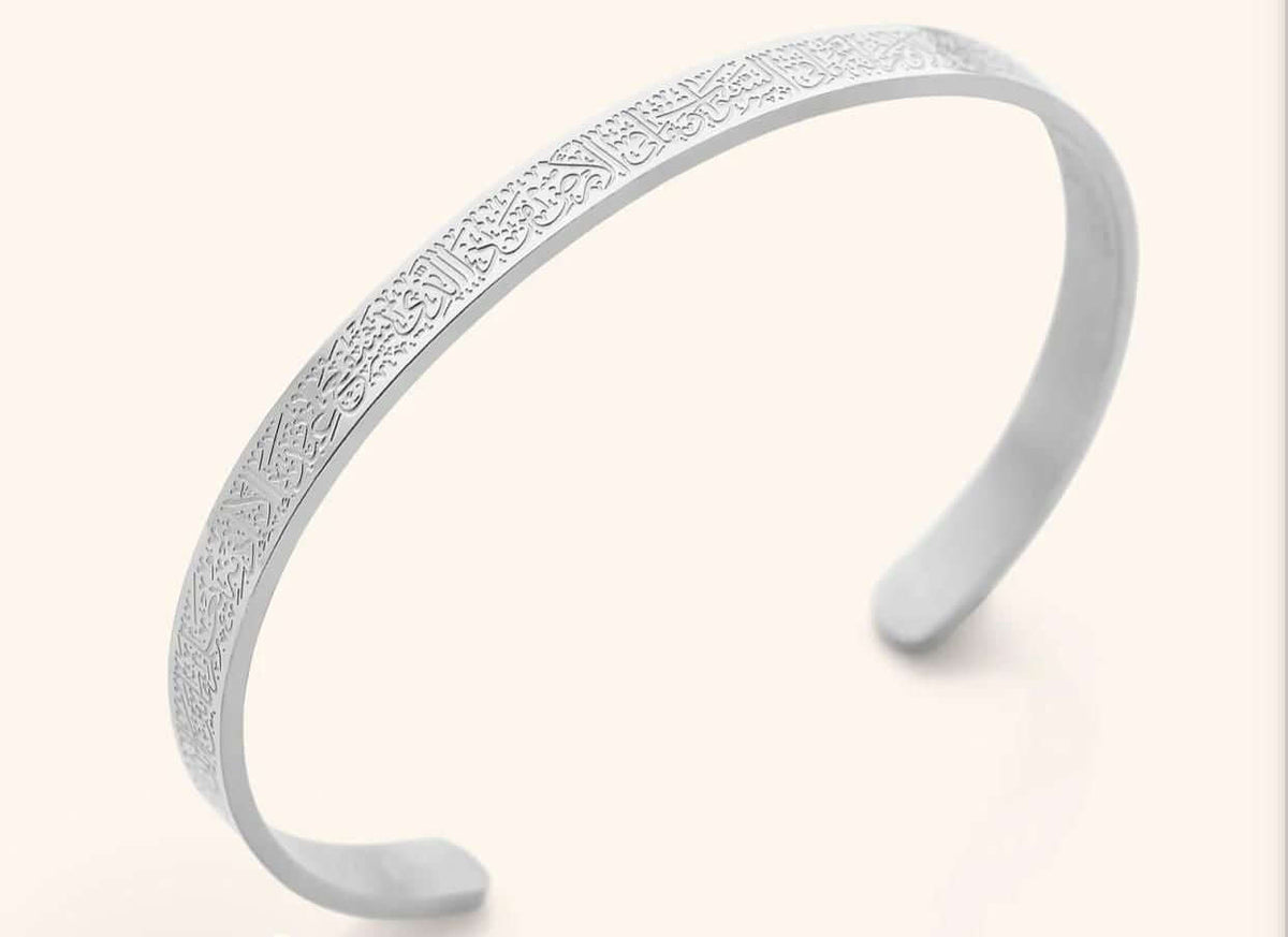 Silver headband with intricate design on a light beige background. Ayatul Kursi engraved bracelet
