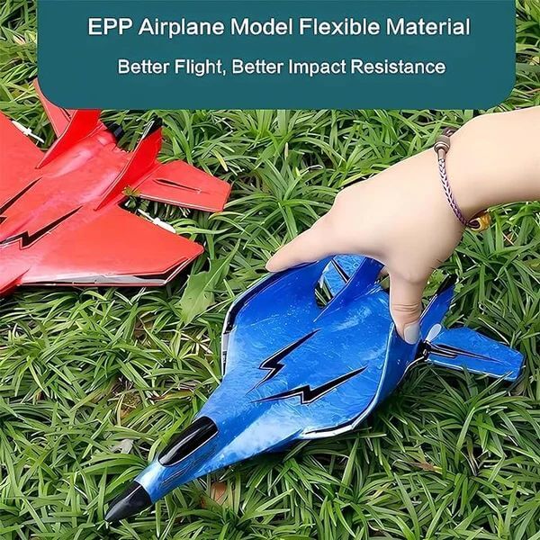 Blue airplane model held by a hand on grass with red airplane model in the background. RC fighter jet remote control airplane
