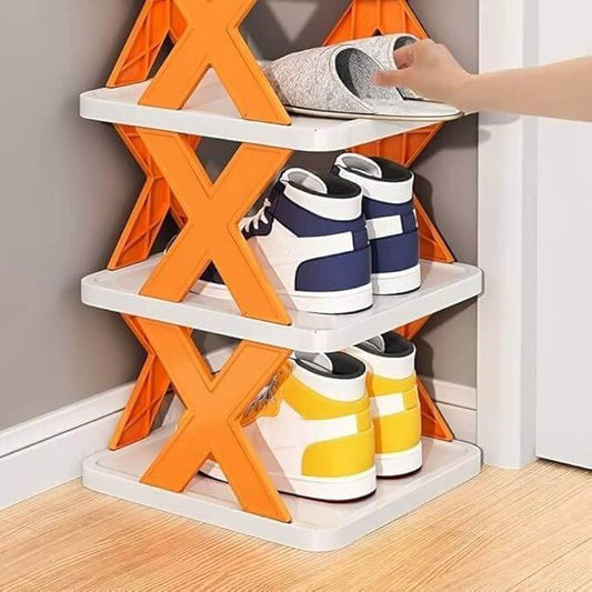 Shoe rack with orange and white design holding various shoes on a wooden floor. X-Shaped Shoe Rack